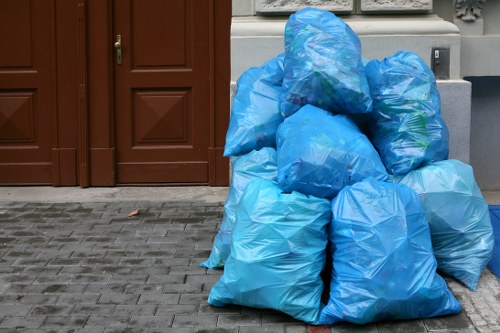 Local waste removal crew loading mixed rubbish into a collection vehicle